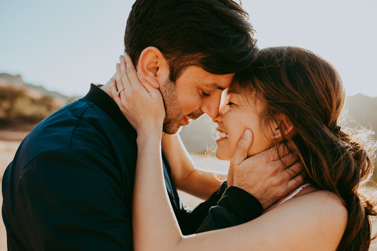 couple holding faces and smiling