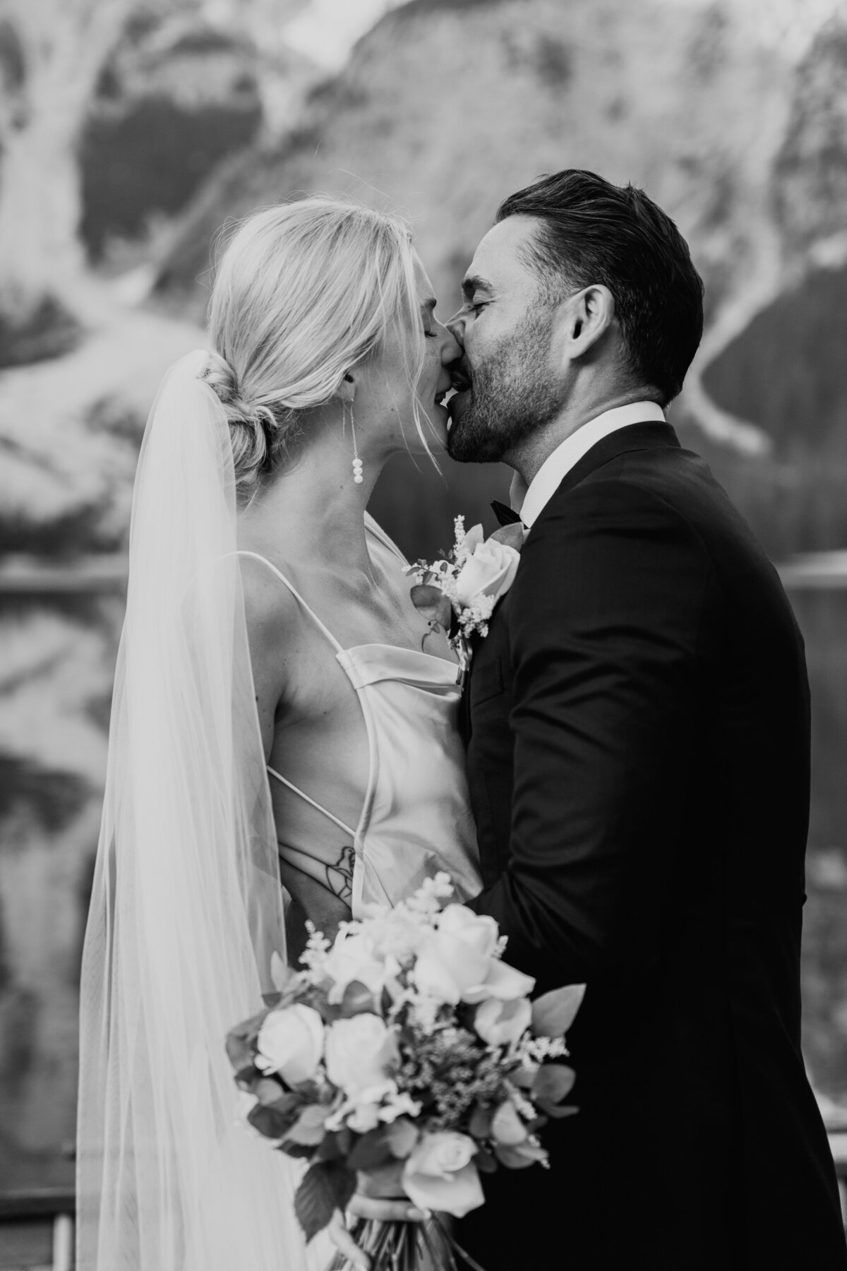 Black and white close-up of couple kissing after ceremony