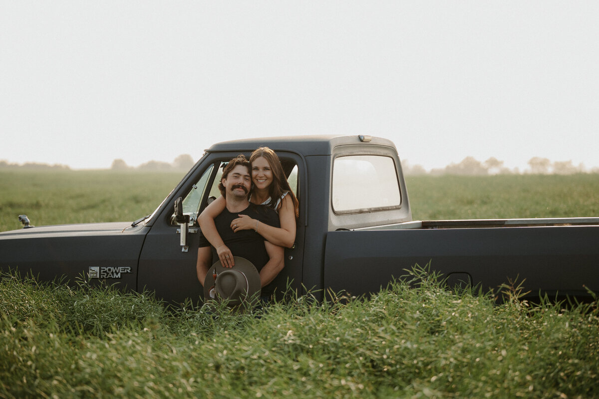 Photograph of couple in an Alberta country field with their old truck