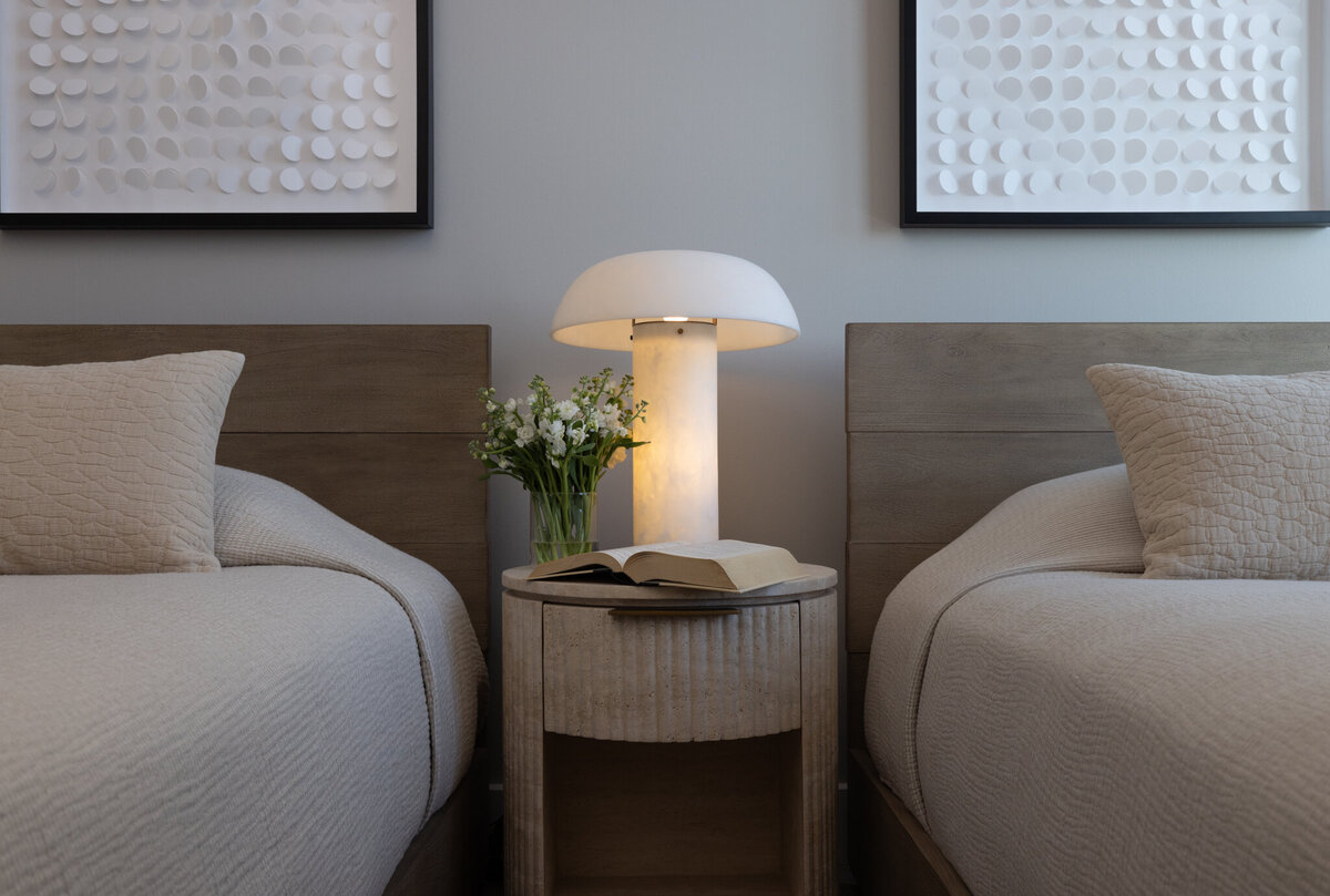 Mountain Modern Guest bedroom at the Deer Valley Hyatt Ski Resort in Park City, Utah, featuring custom twin beds, bespoke billowy bedding, a luxury travertine nightstand, and a modern marble lamp—designed by Valt Interiors in 2024