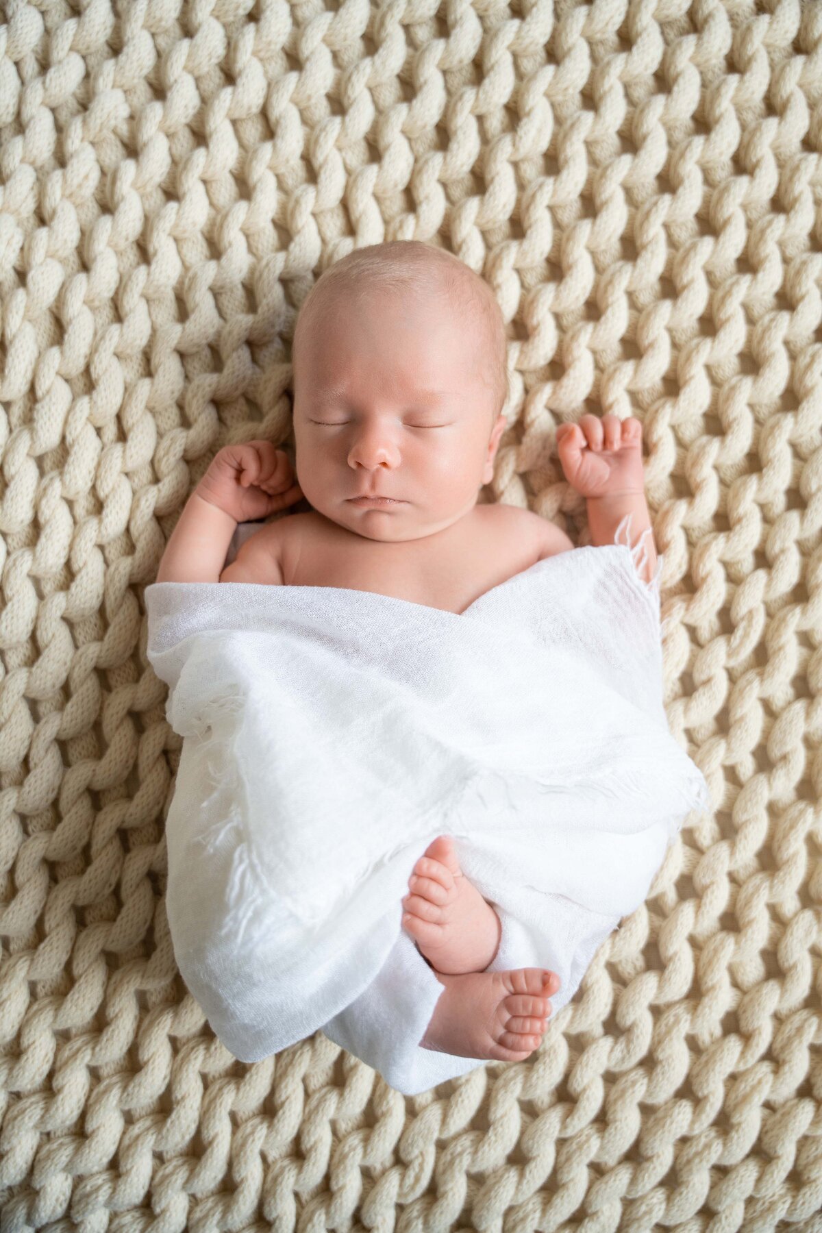 newborn_in_white_wrap_on_blanket
