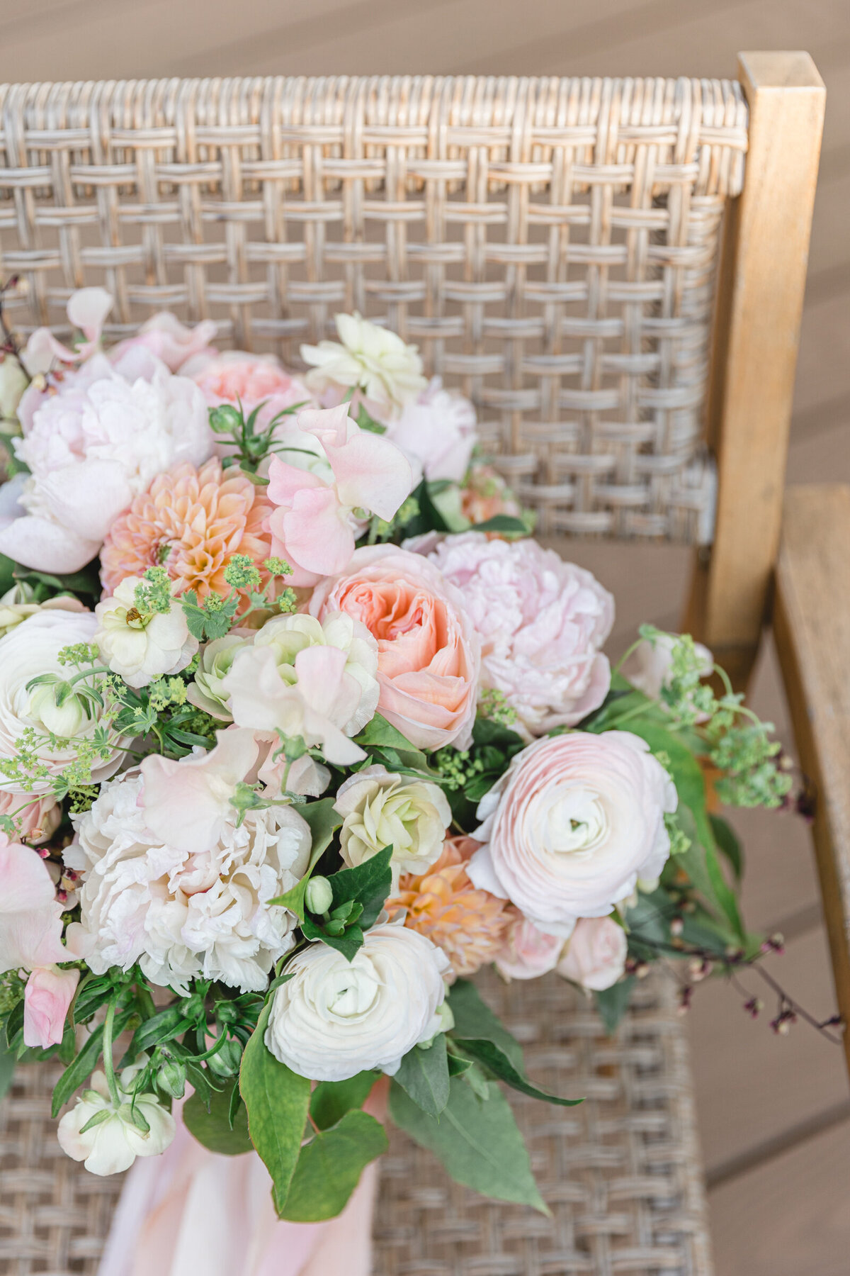 A hand tied peach, blush, and green  wedding bouquet