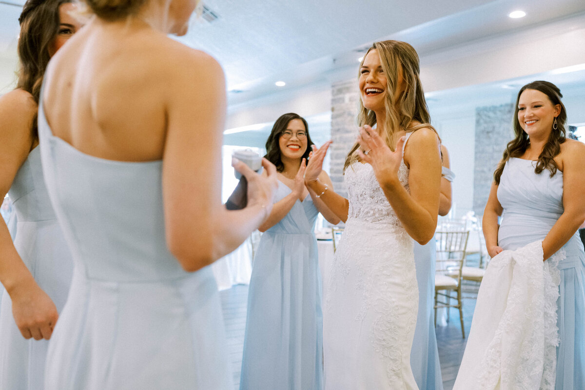 bride-surrounded-by-bridesmaids-during-their-first-look