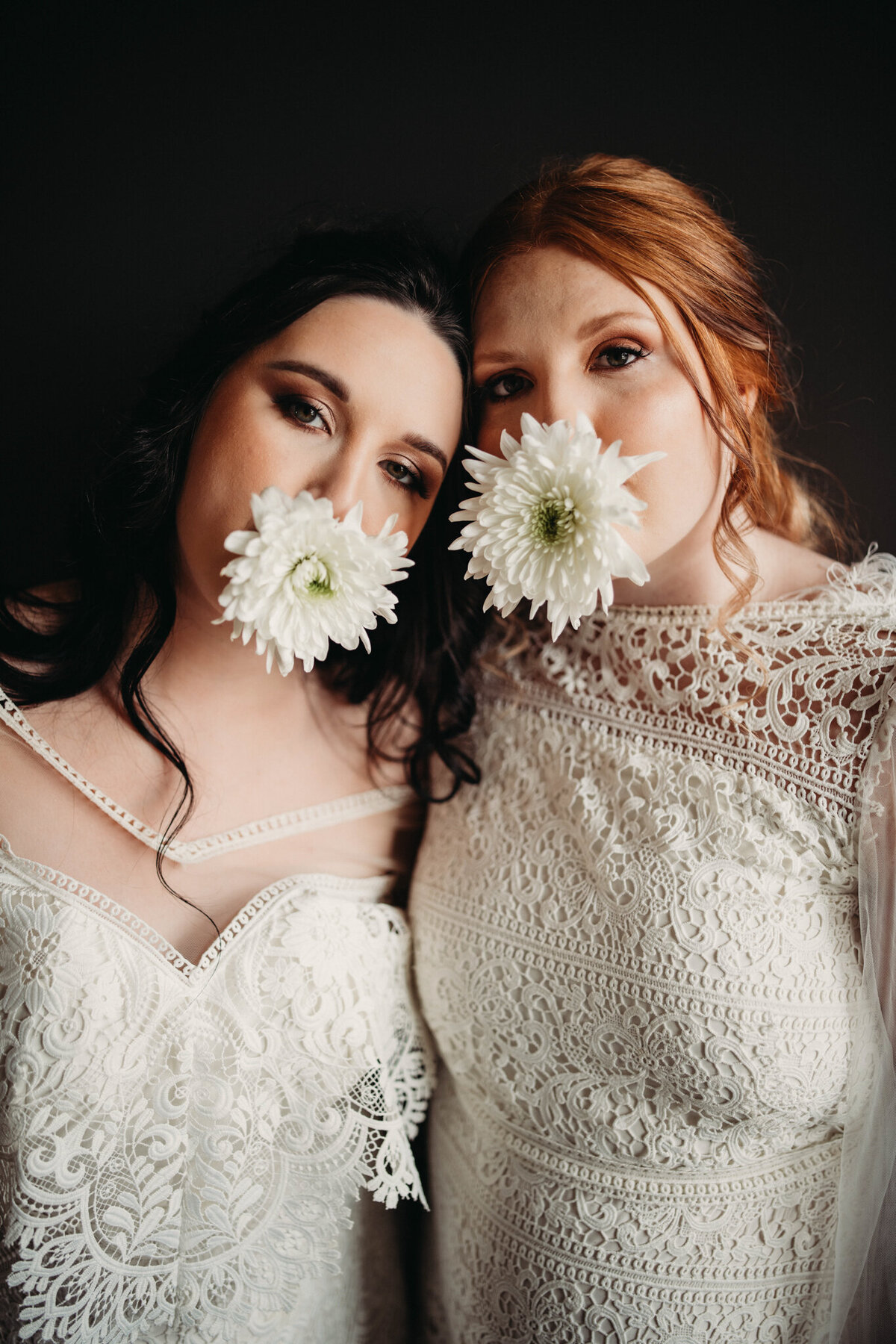 brides pose relaxed with flowers in their mouths for editorial photo
