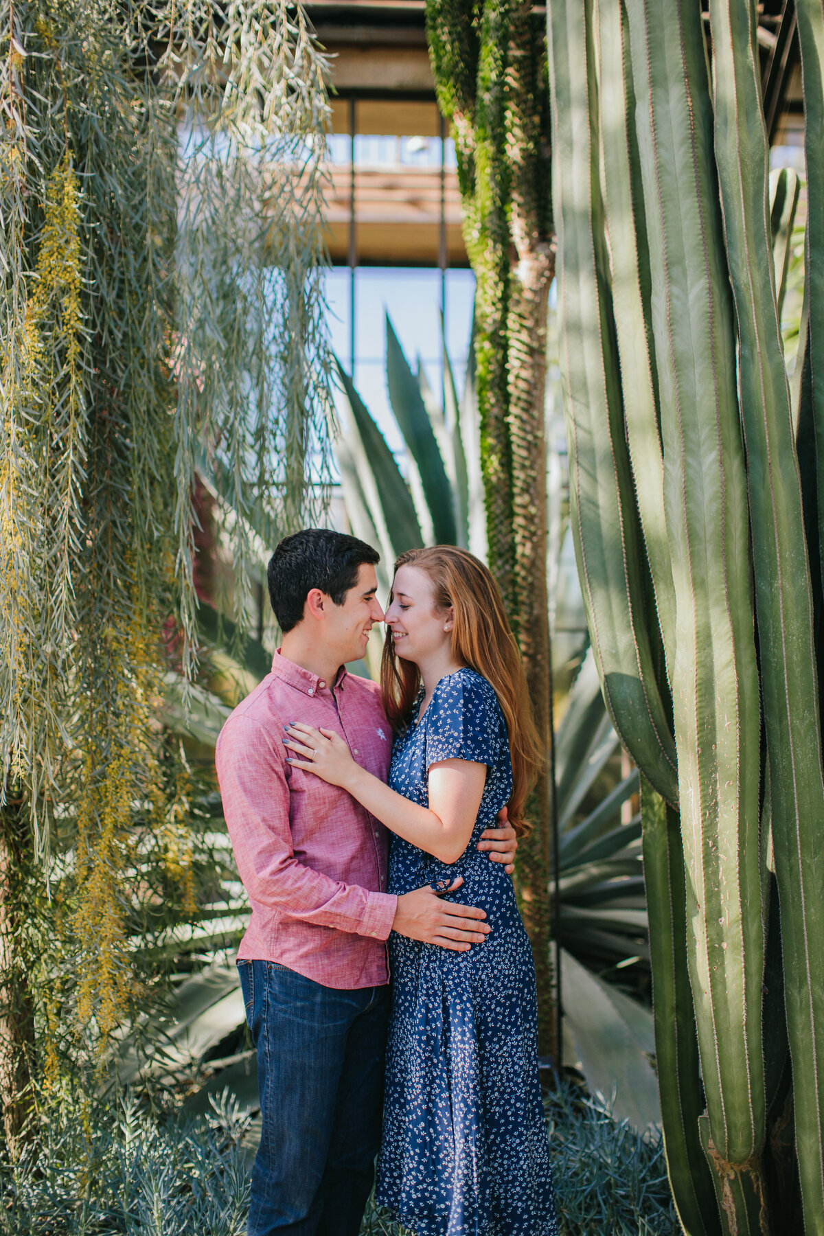 A couple standing close and about to kiss in a desert garden 