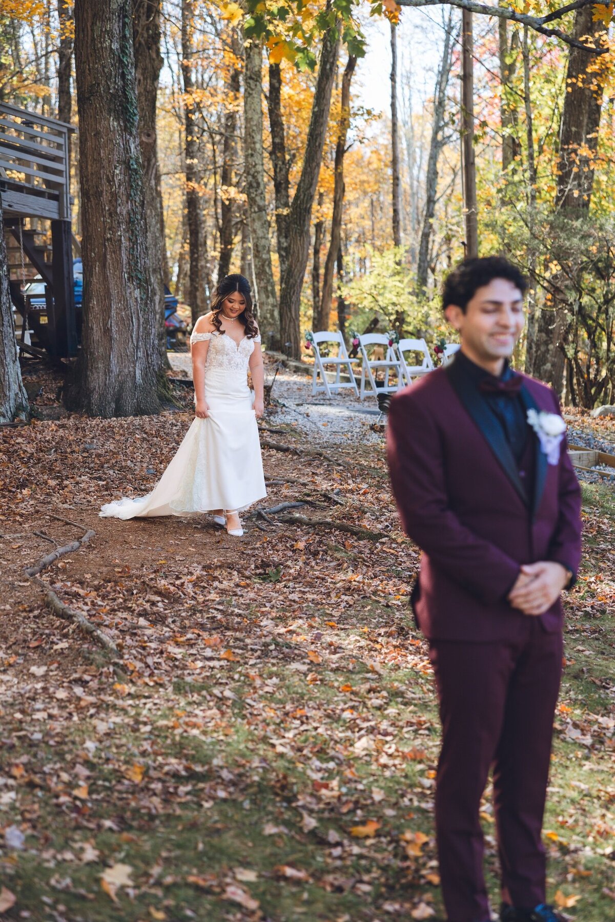 Bride walking up to the groom for their emotional first look in the woods.
