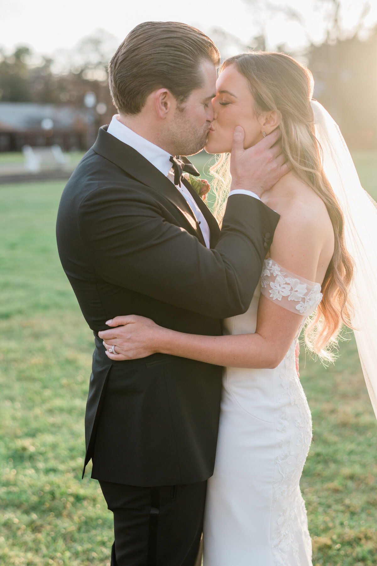 Bride and groom kiss during golden hour