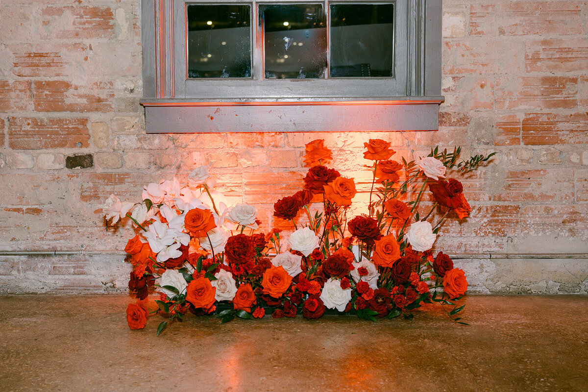 Bold luxury floral installation staged against exposed brick at high-end San Antonio reception