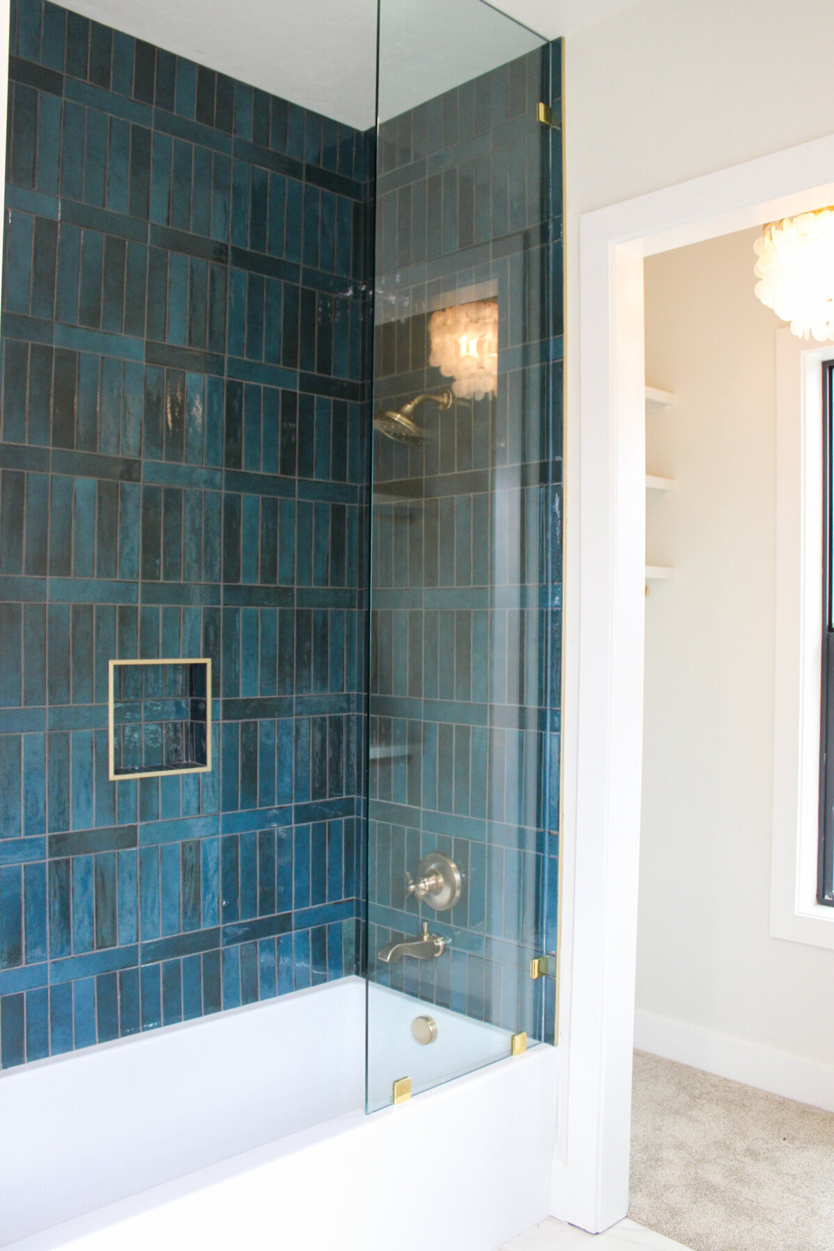 bathtub and shower with glass door and gold fixtures