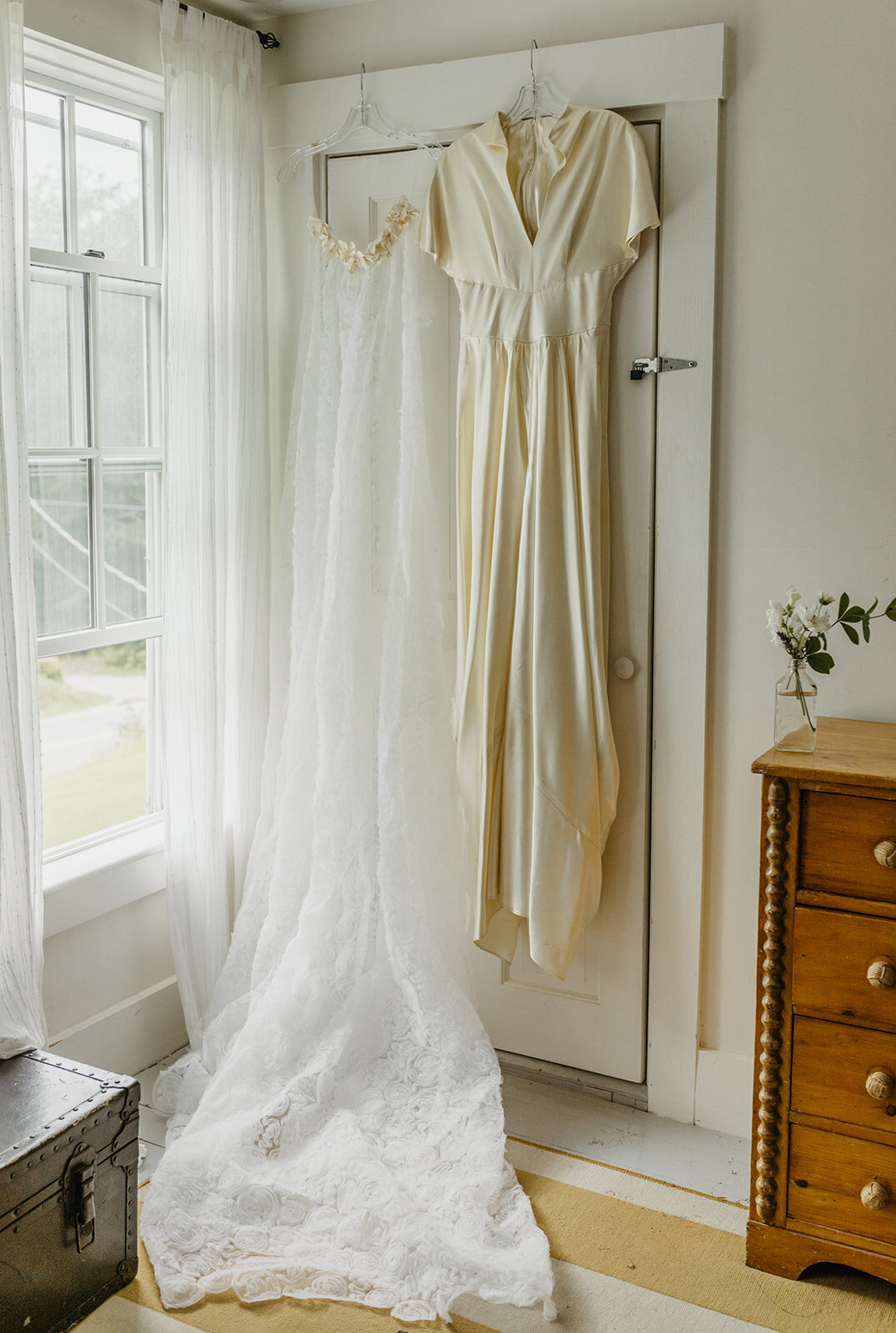 Bridal dresses hung on the front door for Maine wedding
