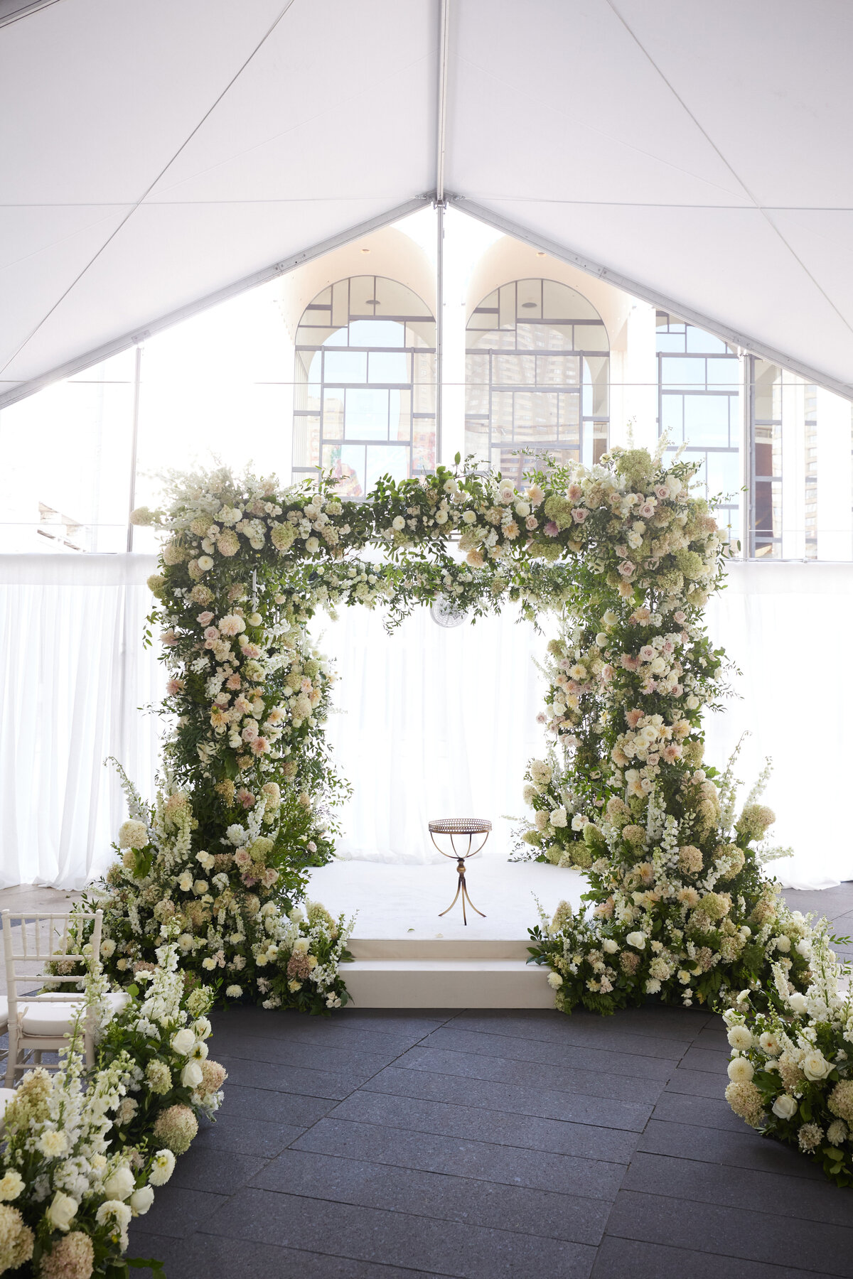 Wedding ceremony alter with green and white florals