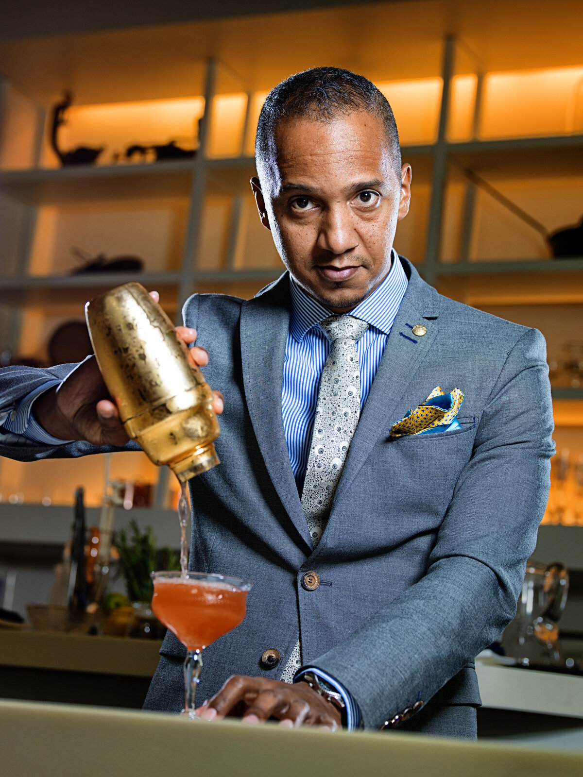 A bartender pouring a cocktail