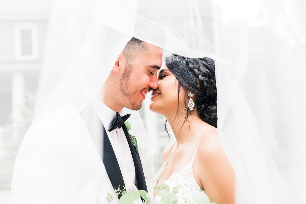 Bride and groom under veil at the ivy place