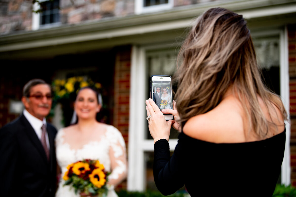 Woman takes photo of bride and groom