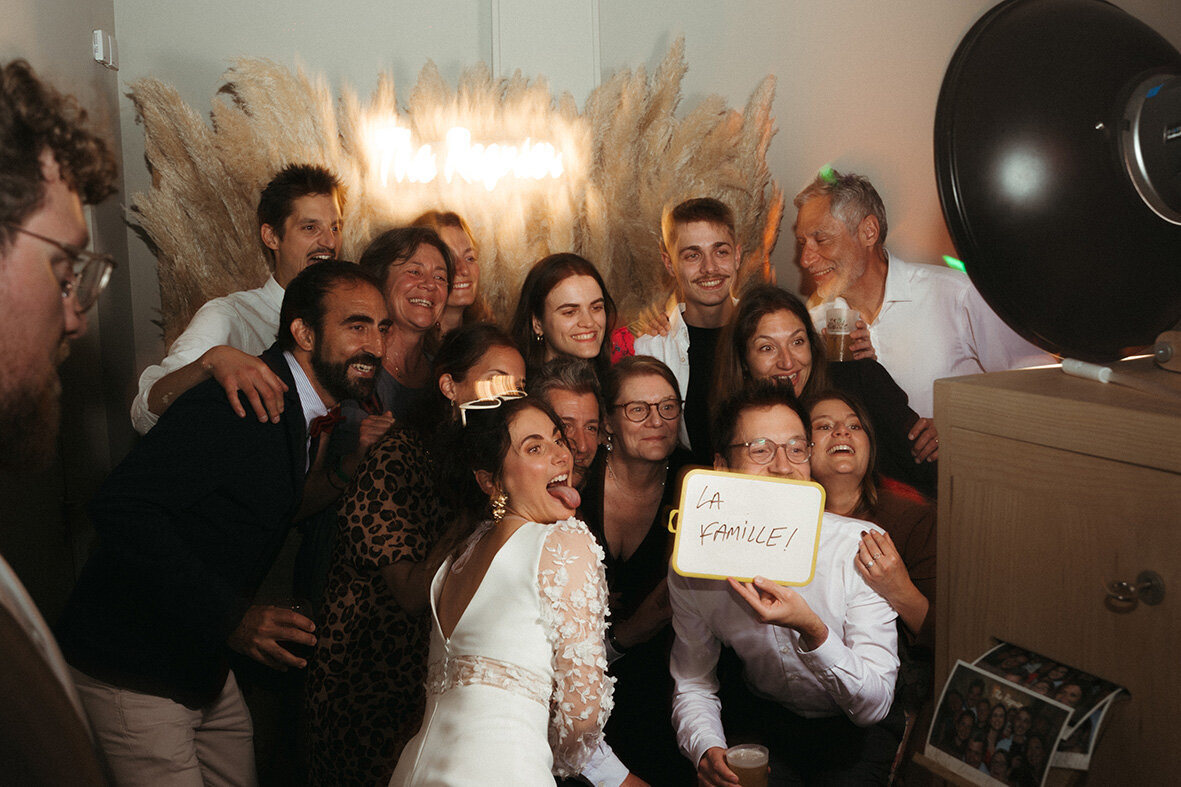 Invités posant pour une photo de groupe avec les mariée lors d'une photobooth au Domaine des Longrais, Bretagne.