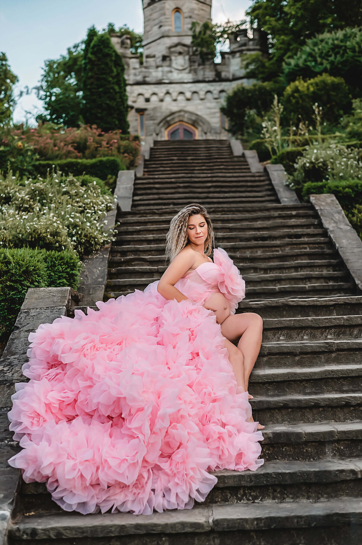 Greater Toronto Maternity Photography at Battlefiield Park, expectant mom in pink gown with ruffles sitting on a stair case.