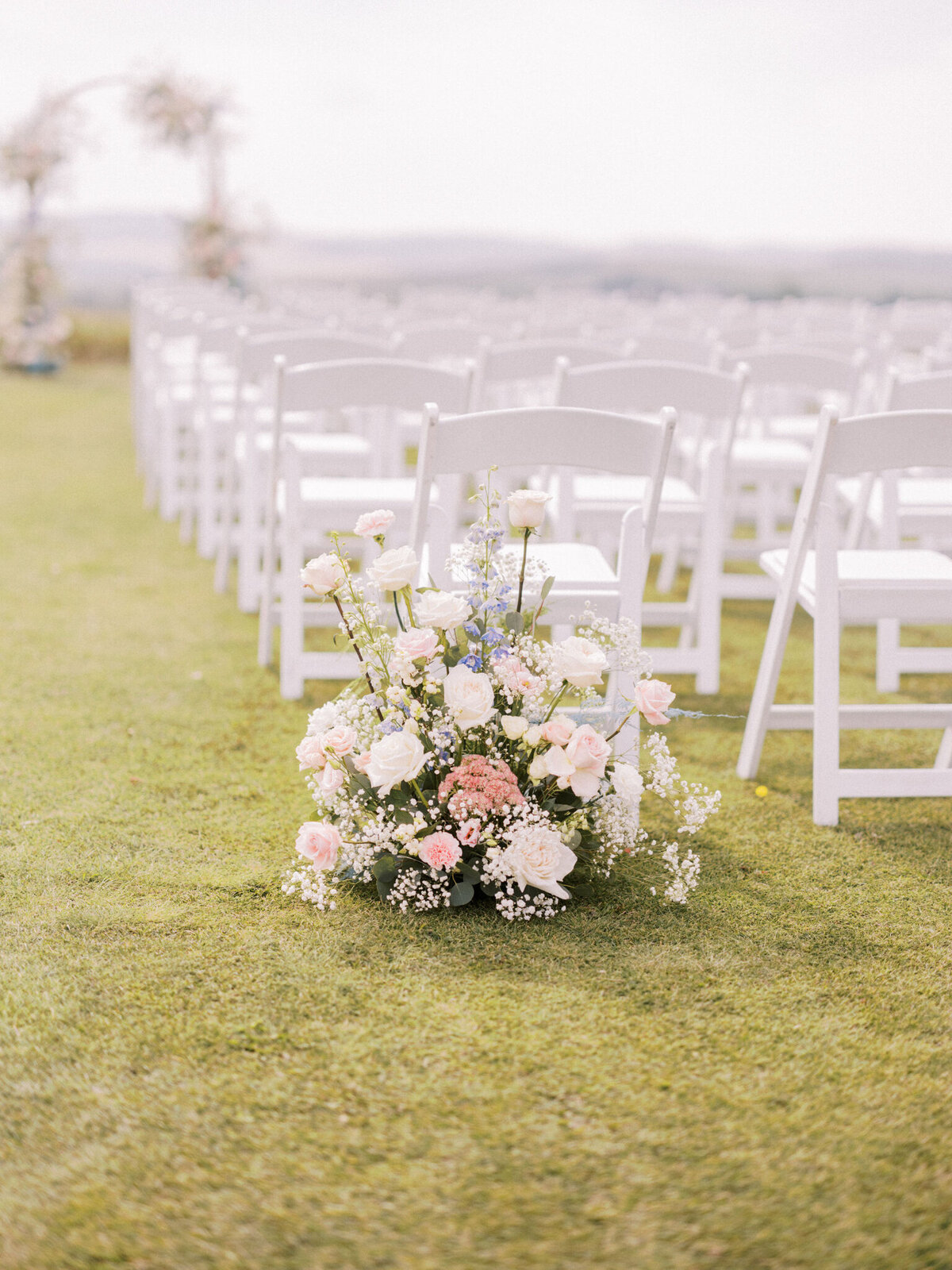Classic pink and white roses at wedding ceremony by Flower Aura By Natasha, classic Calgary, Alberta wedding florist, featured on the Brontë Bride Vendor Guide.