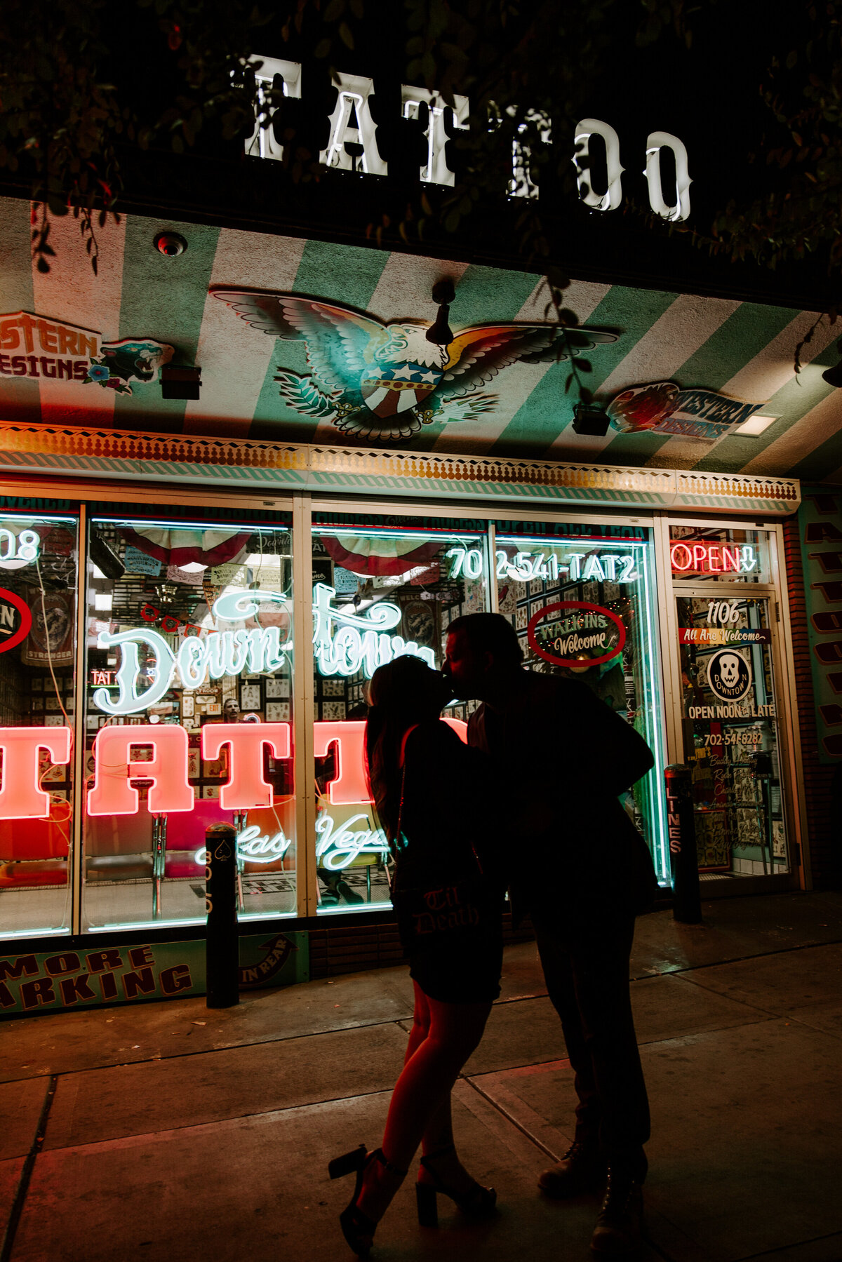 Two people kiss in front of a tattoo shop in Las Vegas.