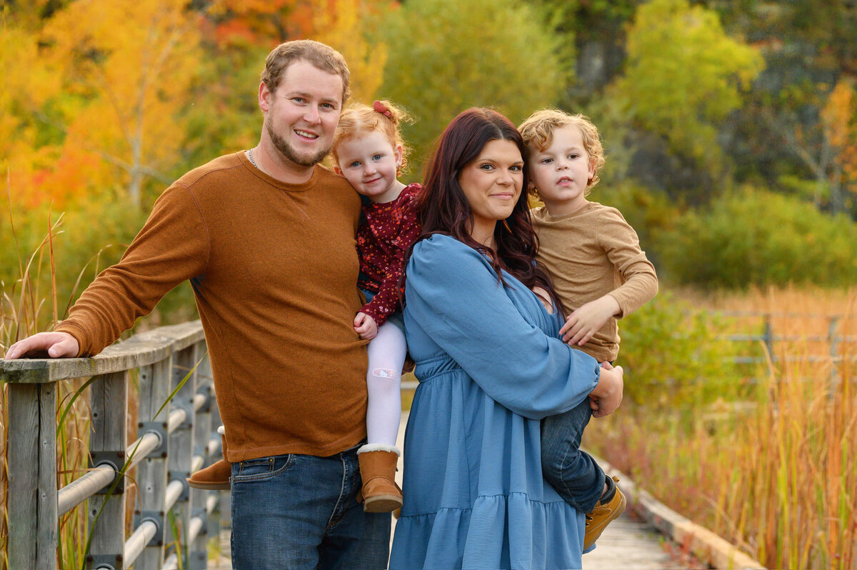husband and wife holding their son and daughter for their fall family photos in Burlington, Ontario