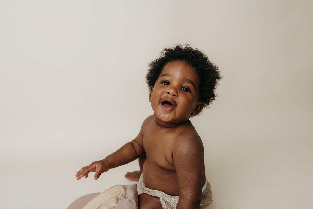 baby in a diaper smiling at camera