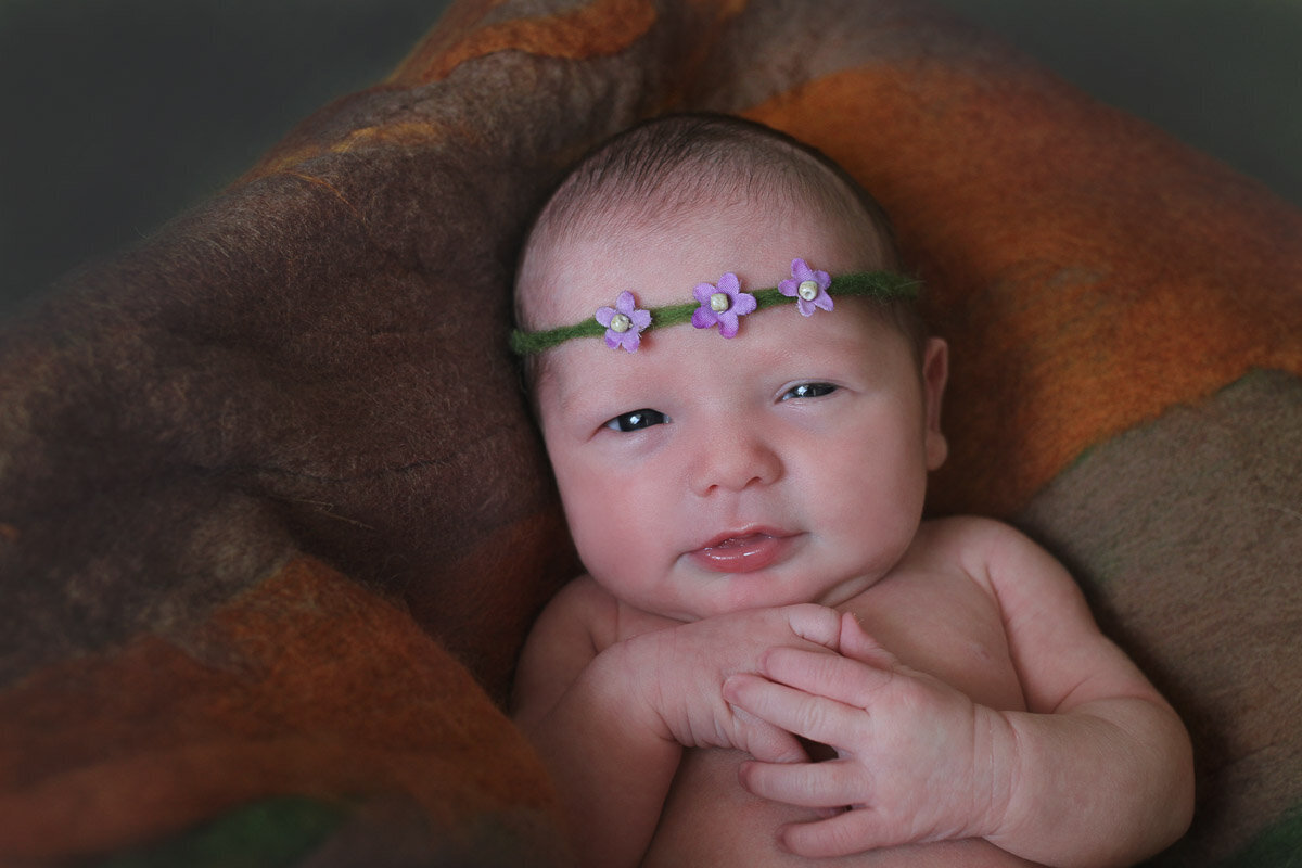 Newborn baby with purple flower hairband newborn photo session Victoria British Columbia
