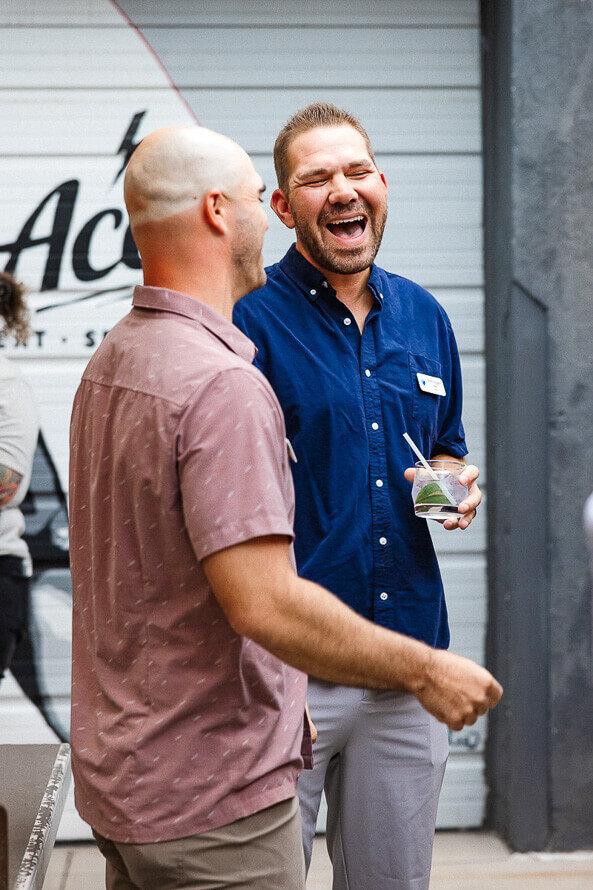 Two men laugh together at Ace in downtown Denver.
