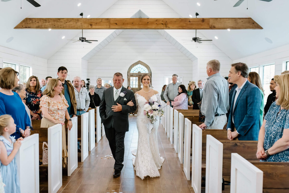 father walking bride down chapel aisle during wedding ceremony at Four Fifteen Estates Wedding and Elopement Venue in New Boston, TX