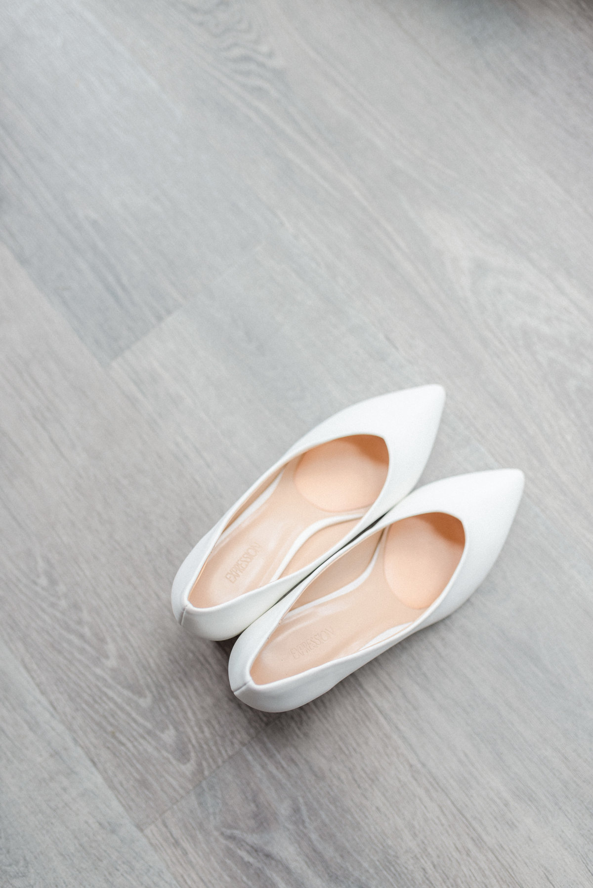 white patten shoes on grey hardwood floor