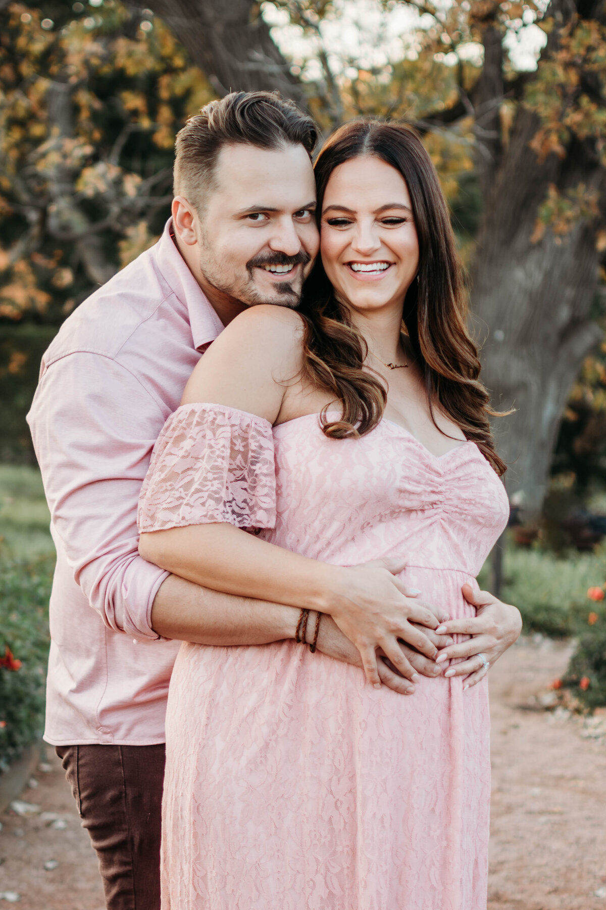 MOm and dad smiling while feeling their baby kick during a maternity photo session in Wheaton, IL