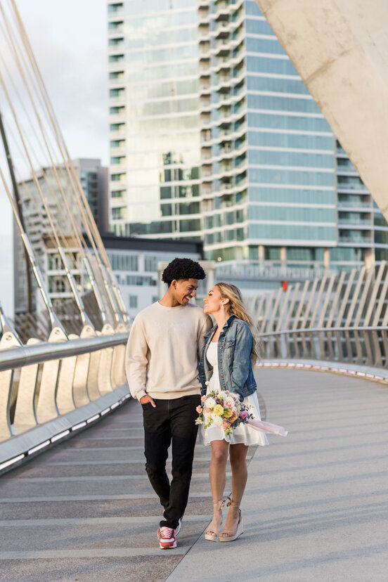 engaged-couple-walking-on-bridge-downtown-san-diego