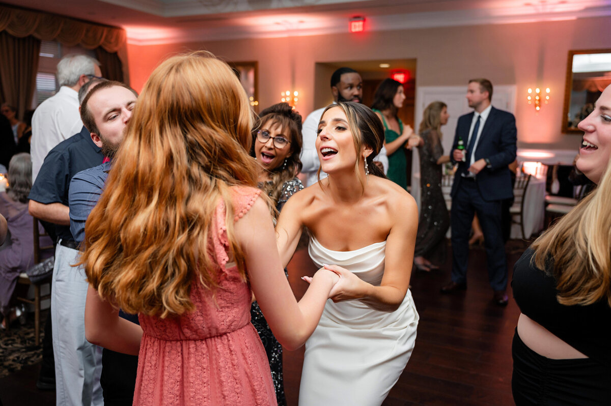 bride dancing with friend at wedding reception