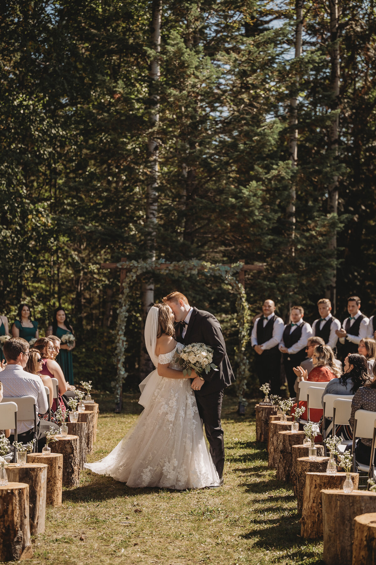 Bride and groom first kiss in aisle