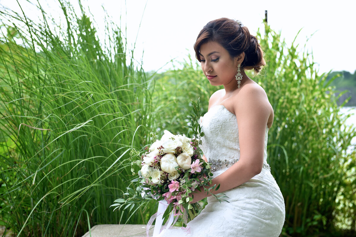 Bride with natural glam makeup and loose waves smiling outdoors – bridal makeup by Lyds Makeup.
