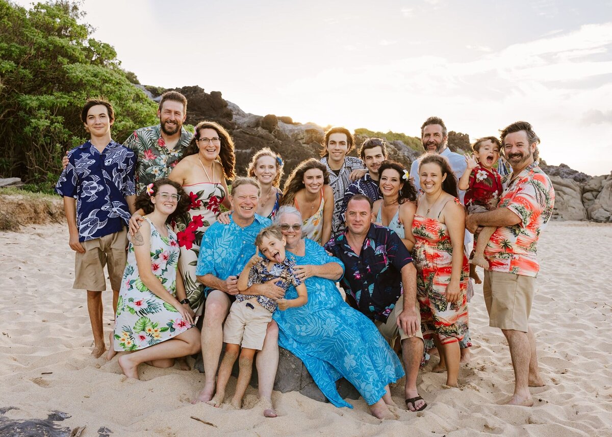 A large family poses for a photo on the beach of Maui.