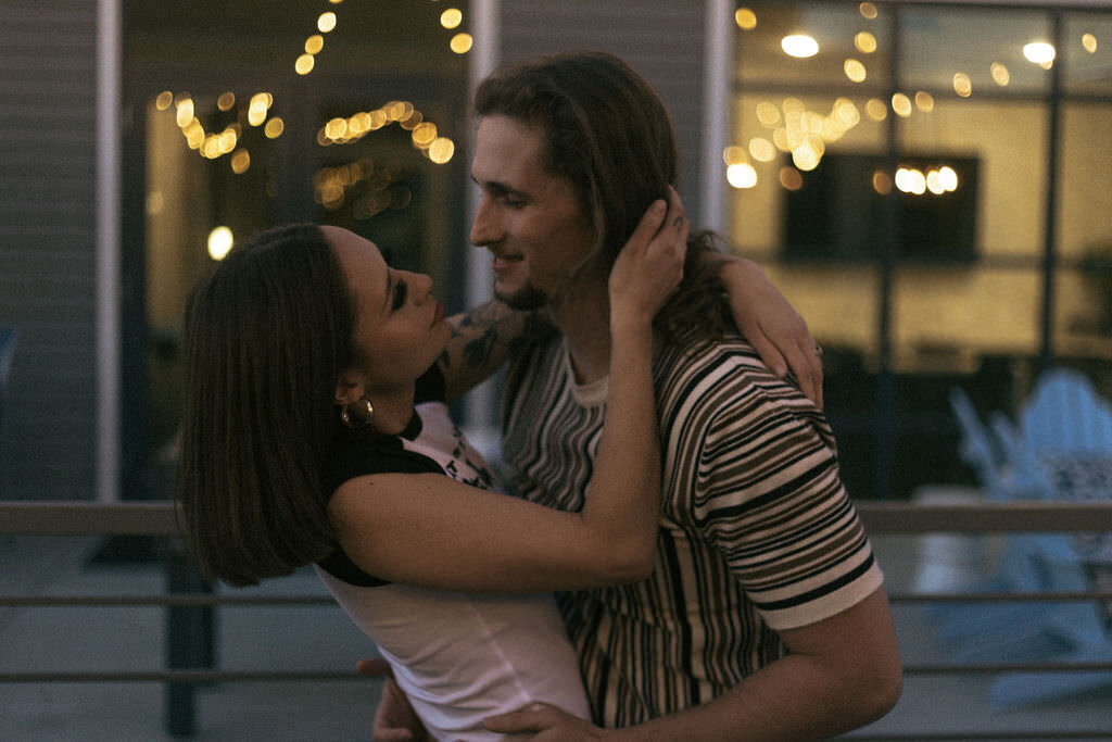 A couple with their arms around each other about to kiss.