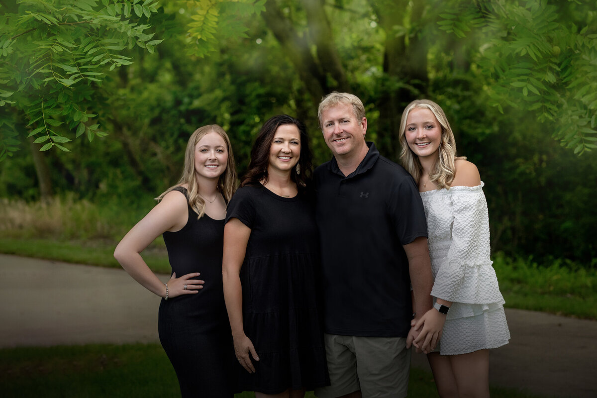 Mom, Dad, and their 2 daughters cuddle together for their Pella Family Pictures