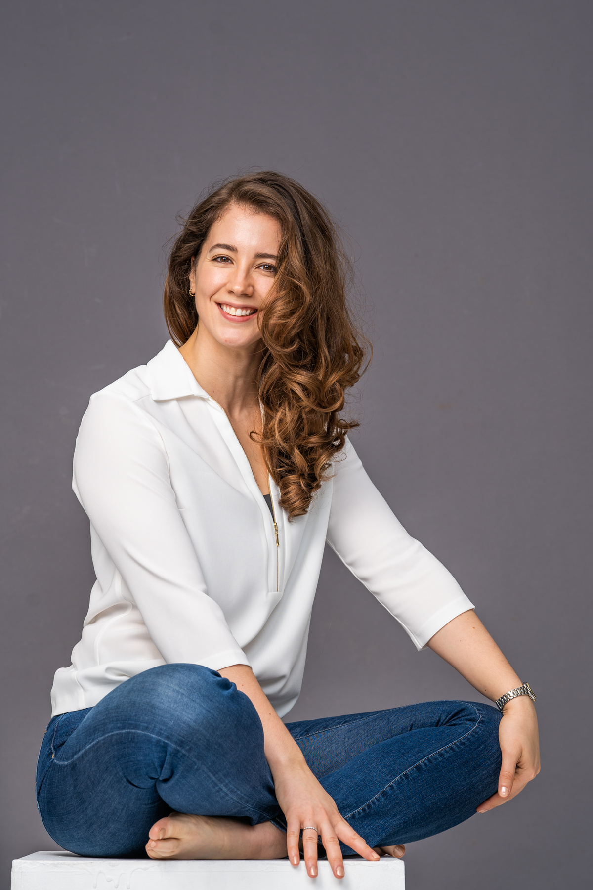 Brunette woman smiles at camera while seated