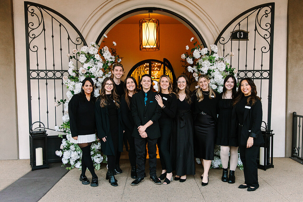 The SoHo63 team poses together in front of the venue’s signature arched entrance, framed by elegant white floral arrangements. Located in downtown Chandler, this wedding and event venue is known for its dedicated staff who help bring every celebration to life with excellence and care.