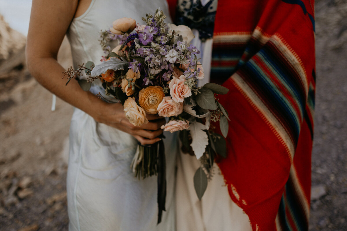 close up of a bride and groom and her floral bouquet