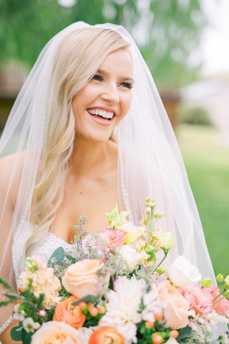 Bride smiling with her wedding bouquet