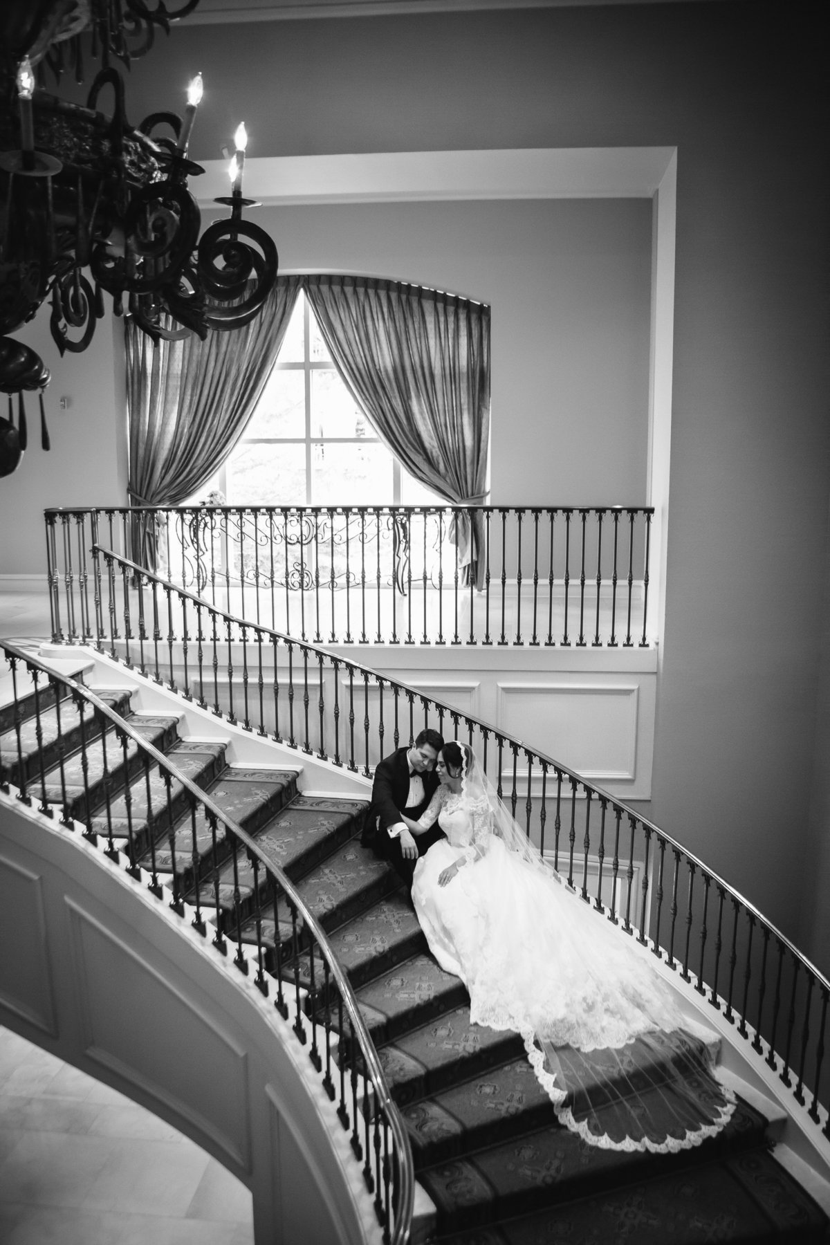 bride and groom sitting on stairs inside Westin Riverwalk wedding venue in down San Antonio by Expose The Heart Photography