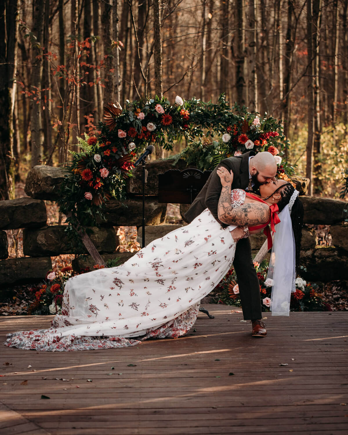 Celebratory dip kiss among fall woods