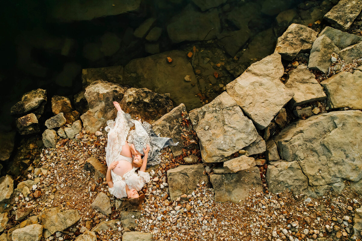 maternity photo in Joplin MO of mom and daughter laying on rocky beach