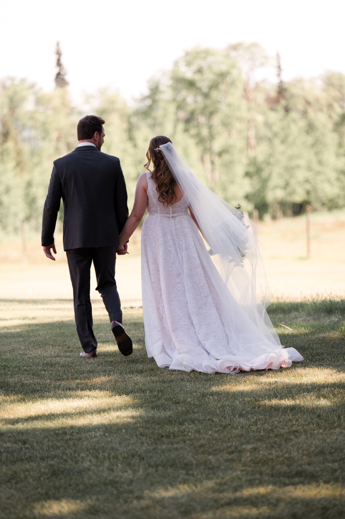 bride and groom running off into a field together