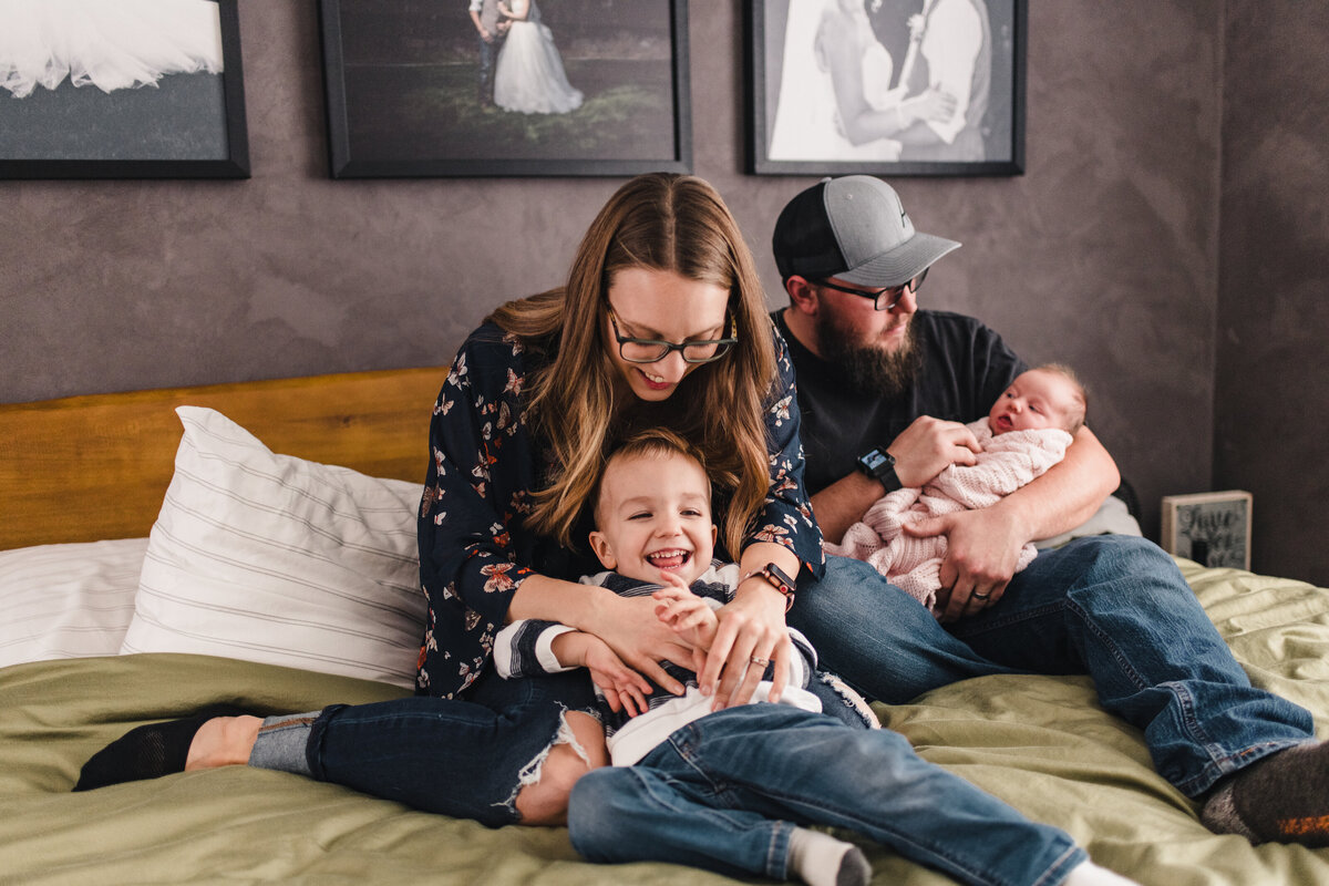 playful family portrait at newborn session at home