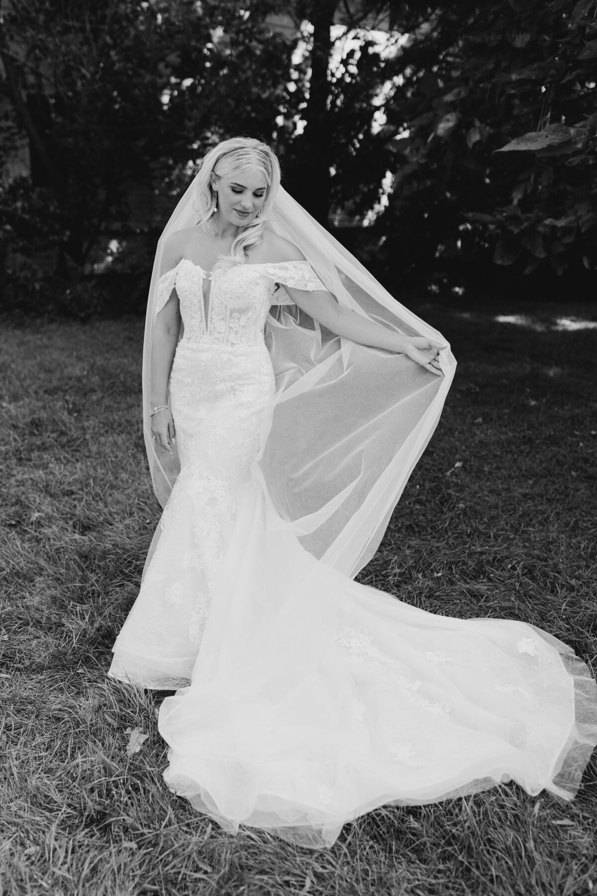 Bride posing in her wedding dress with a flowing train in an outdoor setting in South Bend, Indiana.