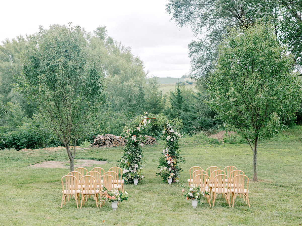 Floral wedding ceremony arch overlooking green vista in Iowa