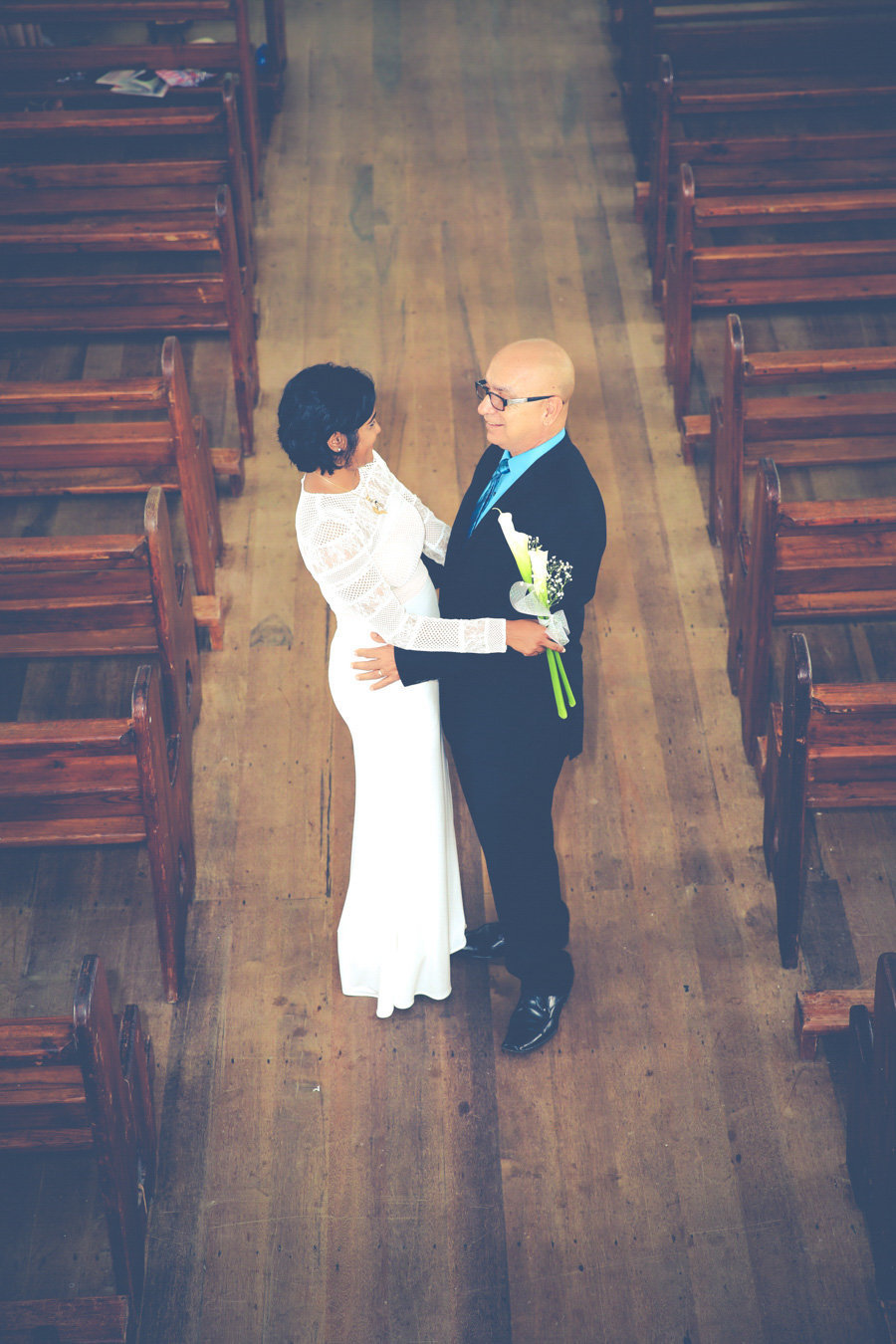 Bride and father-of-the-bride share a moment in church aisle. Photo by Ross Photography, Trinidad, W.I..