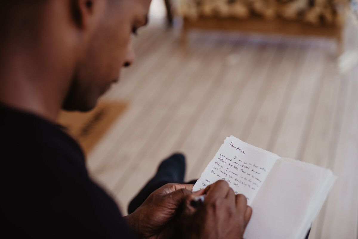 Utah Elopement Photographer captures man writing in vow book