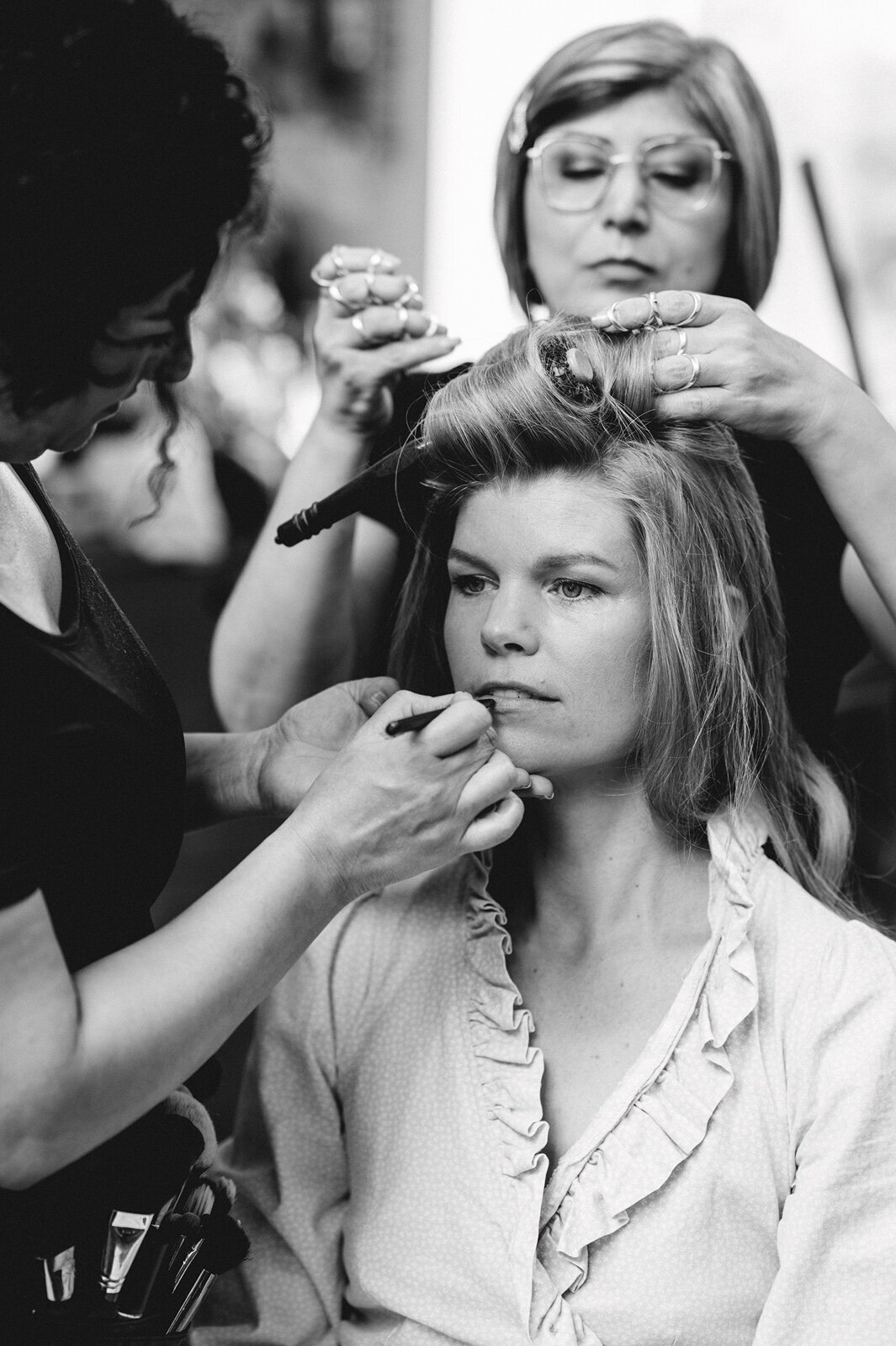 Bruid wordt door kapper en make-up artist klaar gemaakt